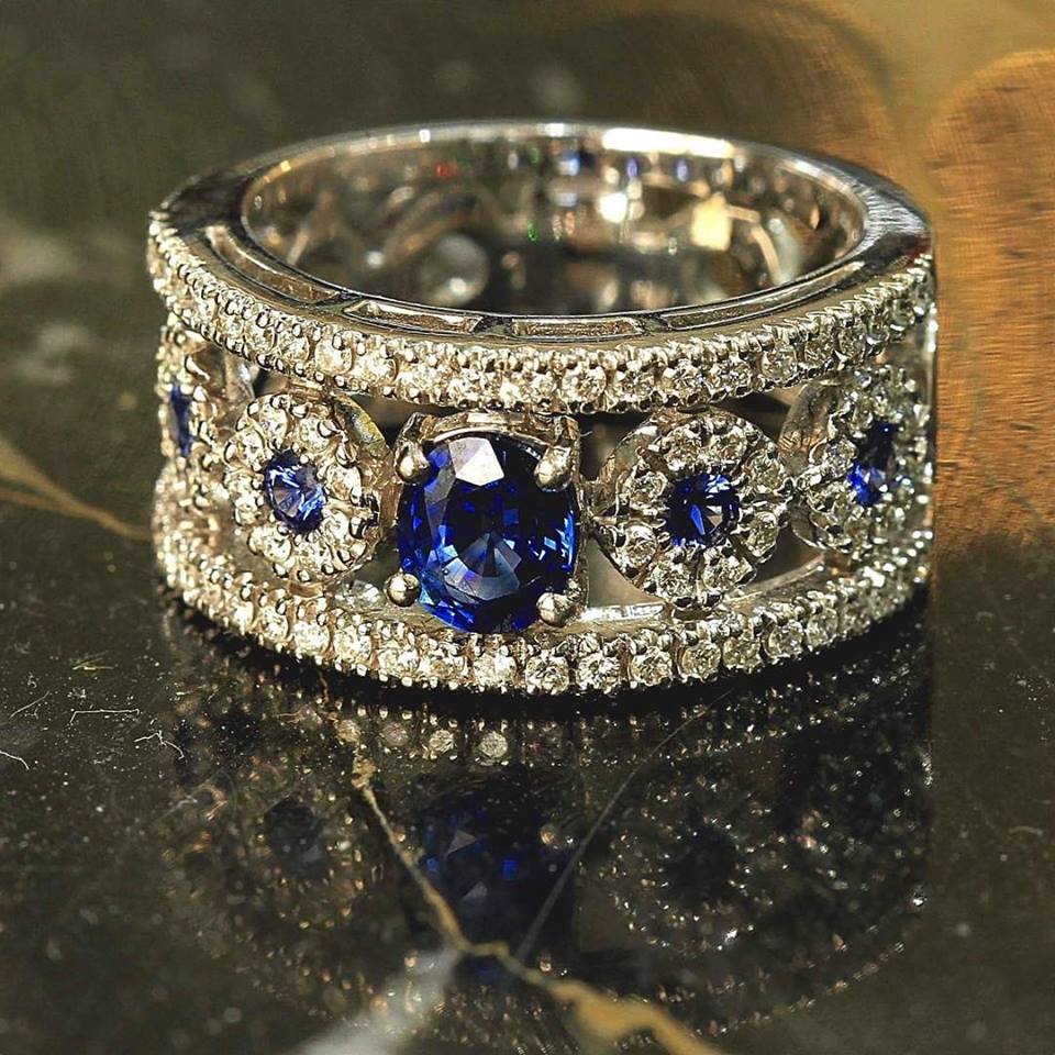 Zlatý prsten se safíry a diamanty. Moderní prsten vyrobený z bílého 18ti karátového zlata zdobený centrálním safírem o váze 0,80 ct a čtyřmi dalšími safíry o jednotlivých vahách 0,07 ct. Diamanty mají celkovou váhu 0,78 ct ( 78 x 0,01 ct) barvu G - H, čistotu VS - VS 1.