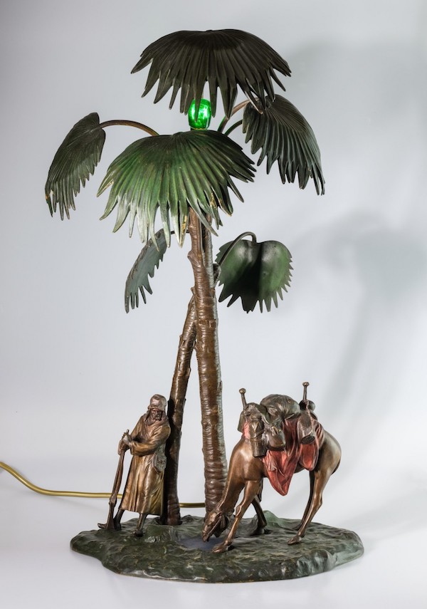Arabský obchodník se svým velbloudem odpočívající pod palmami - lampa
